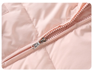Detailed macro view of the silver metal zipper and pink quilted fabric of the puffer jacket