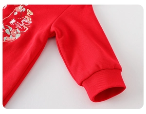 Detailaufnahme des roten chinesischen Baby-Stramplers mit Blumenstickerei und Rippstruktur