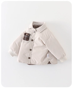 Détail d'un manteau d'hiver pour bébé avec poche à carreaux et boutons en bois chic