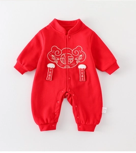 Détail d'un body d'hiver rouge pour bébé avec broderie dorée et pendentifs de nœuds chinois