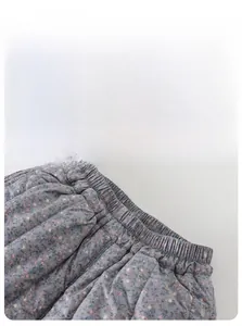 Detailed close-up of elastic waistband on thick floral winter leggings for baby girls