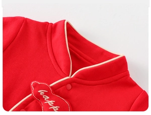 Close-up of red newborn romper with white happy embroidery and cloud patch detail