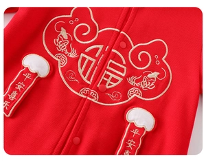 Détail d'une barboteuse rouge pour bébé avec broderie du caractère Fu et nuages