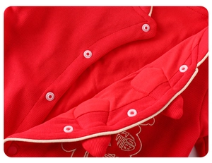 Detailed macro view of embroidered Fu character on red newborn winter bodysuit
