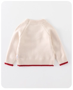 Detail view of the soft knitted texture and red ribbed cuffs on this baby winter sweater