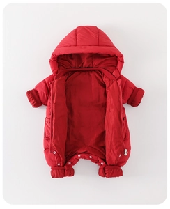 Détail d'une combinaison d'hiver rouge pour bébé avec fermeture éclair et poignets coupe-vent