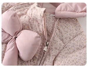 Close-up of pink floral quilted baby jacket featuring a large decorative bow and zipper