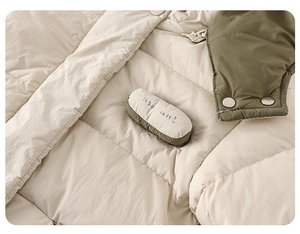 Detail view of winter baby jacket showing contrast stitching and quilted texture