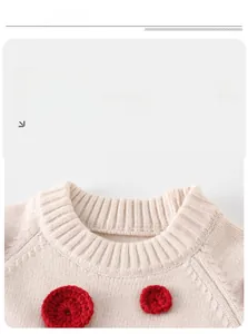 Detailed macro view of the ribbed neckline and red hand-crocheted flowers on white sweater
