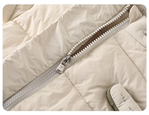 Detail of baby winter jacket showing smooth zipper, metal puller and quilted fabric texture