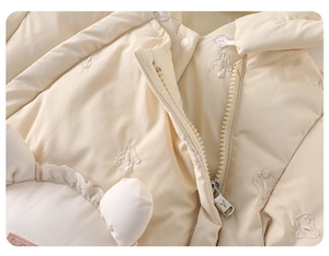 Macro detail of baby romper neckline with rabbit embroidery and smooth zipper closure