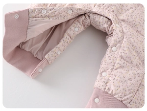 Detail of baby winter romper showing floral print, corduroy texture, and snap buttons