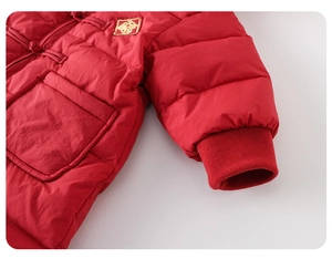 Détail d'une combinaison d'hiver rouge pour bébé avec nœuds chinois et broderie Fu