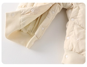 Detailed macro view of snap fasteners and cute rabbit embroidery on baby winter romper