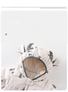 Detail of baby winter jumpsuit hood with 3D reindeer antlers and soft cream fabric