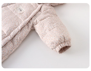 Detailed view of baby floral puffer jumpsuit showing elastic cuffs and lace handmade label