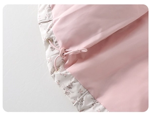 Detalle de chaqueta de invierno para bebé con flores rosas y cordón ajustable