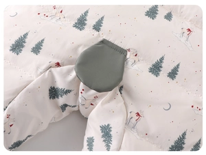 Detail of baby winter jumpsuit with deer and forest print and horizontal quilting