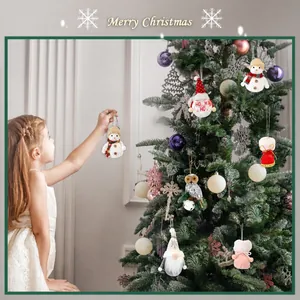 Close-up of plush snowman and gnome ornaments being hung on a festive Christmas tree
