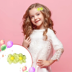 Detail of plush twin flower hair clips in green and yellow on a pink background