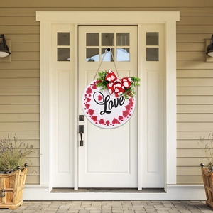 Close-up of heart-patterned wooden welcome sign with Love text and bow on a white door