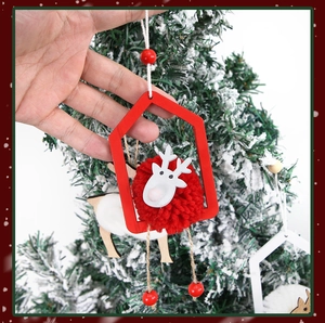Détail d'une suspension de Noël en bois avec pompon rouge et tête de renne blanche