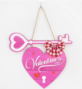 Close-up of heart-shaped Valentine's Day wooden hanging sign with key and bow