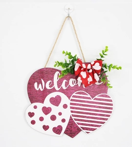 Detail of wooden heart welcome sign with stripes, polka dots and red bow decoration