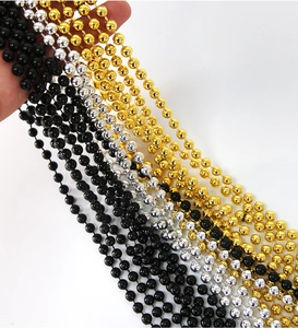 Macro detail of black, gold and silver plastic bead necklaces for party decorations