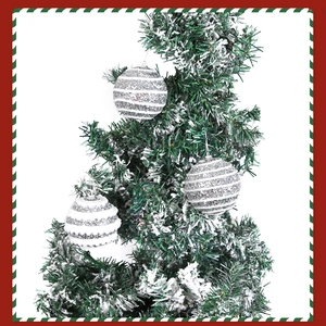 Detail of silver sequined Christmas ornaments hanging on a snowy tree branch