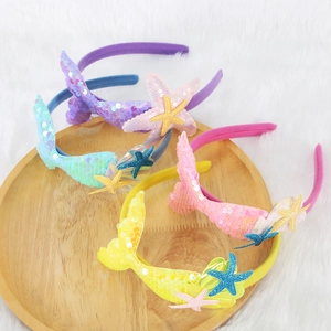 Colorful mermaid tail headbands with starfish and shell details for kids ocean parties