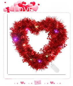Detail of red heart tinsel wreath with LED lights and white battery compartment