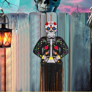Detail of Day of the Dead skeleton hanging decor with colorful sugar skull and orange tassels
