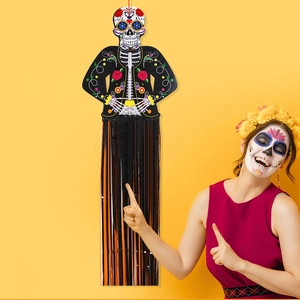 Close-up of Mexican Day of the Dead hanging skull ornament with black and orange tassels