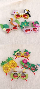 Macro shot of tropical party glasses with glitter felt flamingo and pineapple designs