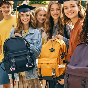 Dettaglio di ciondoli in acrilico laurea 2025 con tocco e diploma fissati agli zaini