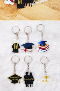 Dettaglio portachiavi laurea in acrilico con tocco nero e oro, diploma e logo d'orgoglio 2025