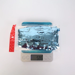 Blue metallic tinsel curtain party decoration in packaging shown weighing 58.6g on a scale