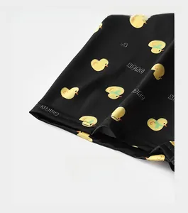 Detail of reinforced cuffs on black men's boxers with yellow duck print pattern