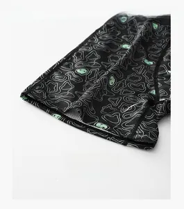 Macro shot of reinforced leg cuffs on men's quick-dry sports leggings with green print