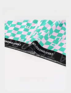 Gros plan détaillé de la ceinture élastique noire avec texte blanc sur boxer à carreaux