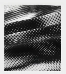 Close-up of breathable ice silk fabric with black and white gradient dot pattern
