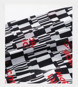 Close-up of ice silk fabric featuring black white geometric patterns and red text detail