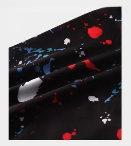 Close-up of black ice silk fabric featuring red, blue, and white ink splash patterns