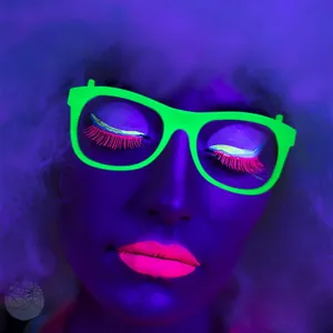 Close-up of neon green glowing glasses with matching UV makeup for party decorations