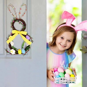 Handmade Easter bunny vine wreath with yellow bow and eggs hung on a white door