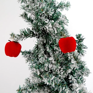 Pendentif pomme de Noël rouge floqué avec cordon doré sur une branche enneigée