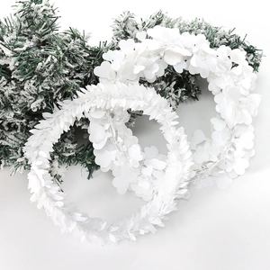 White sequin Christmas wreath set with heart and leaf shapes on snowy pine branches