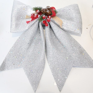 Detailed view of silver glitter Christmas bow with natural pine cone and red berries