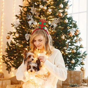 Woman wearing Christmas reindeer antler headband with sequins and gift box ornament